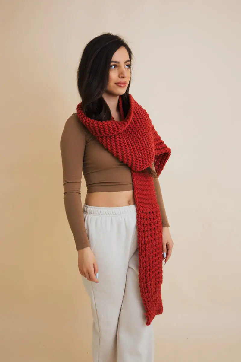 Red-brown waffle-knit scarf with cozy chunky weave, worn around the neck
