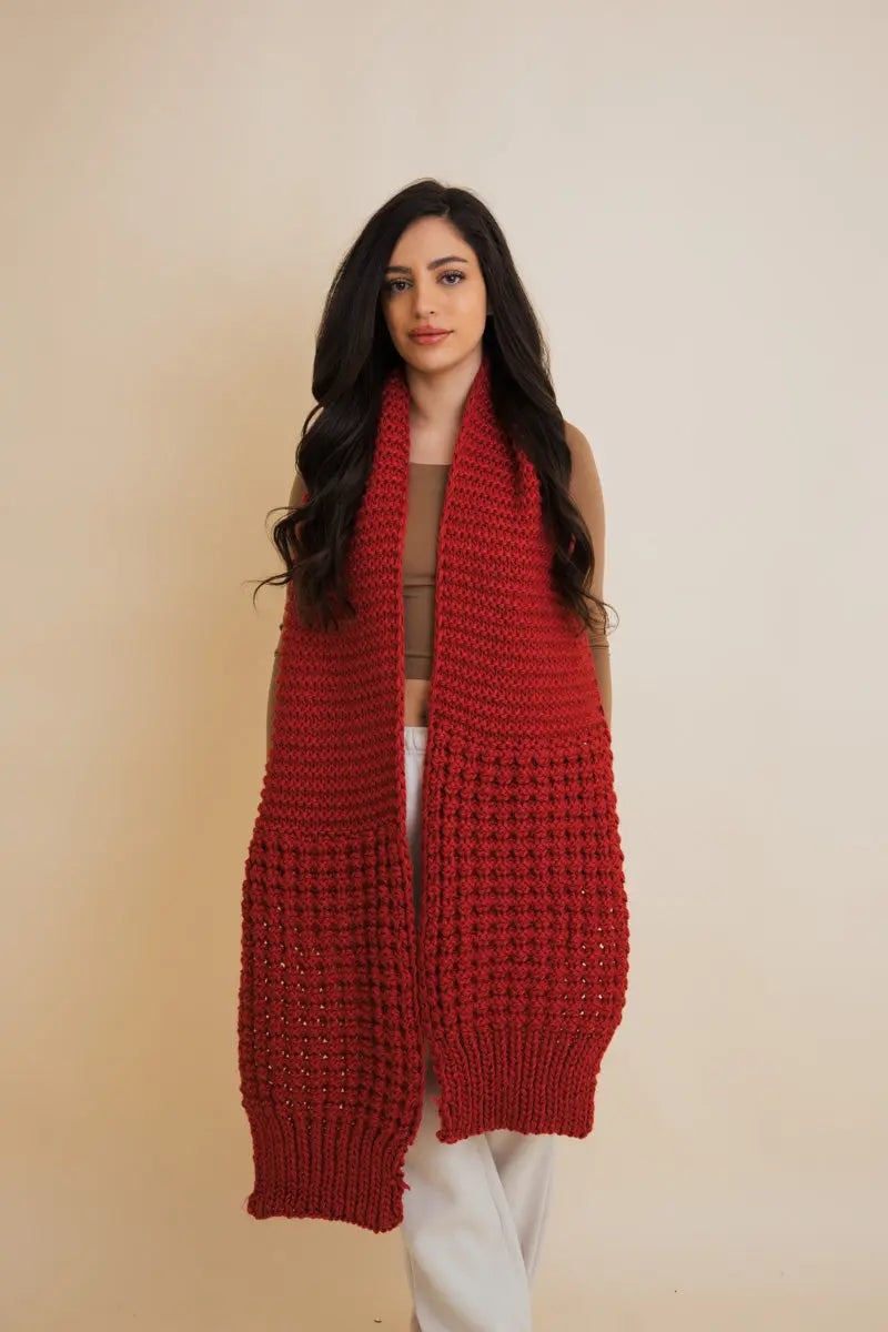 Red waffle-knit scarf with fringed ends, draped over the front
