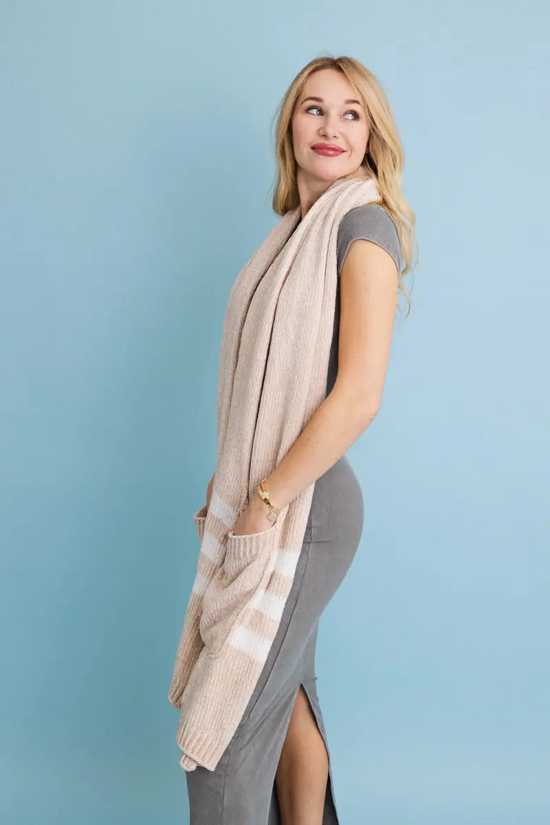 Beige chenille pocket scarf draped over shoulders with front pocket detail and striped hem.