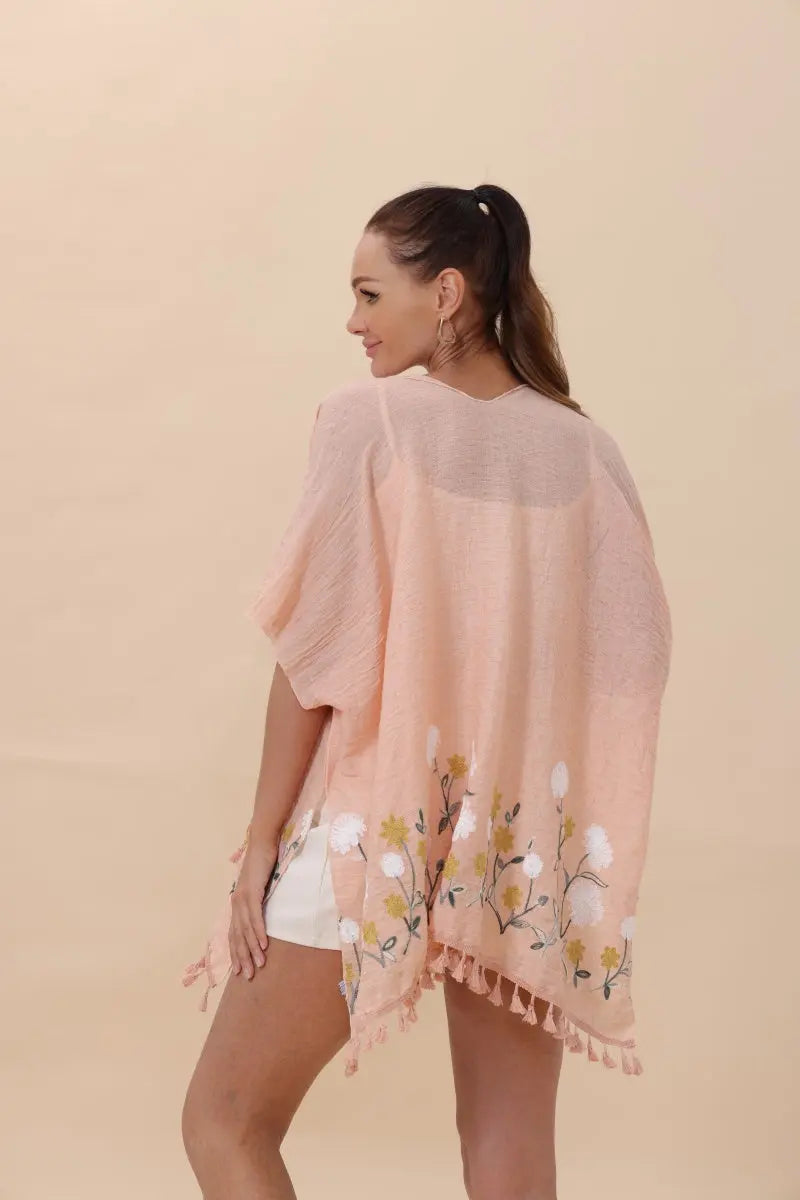 Light pink floral kimono cardigan with tassel trim and loose draped sleeves