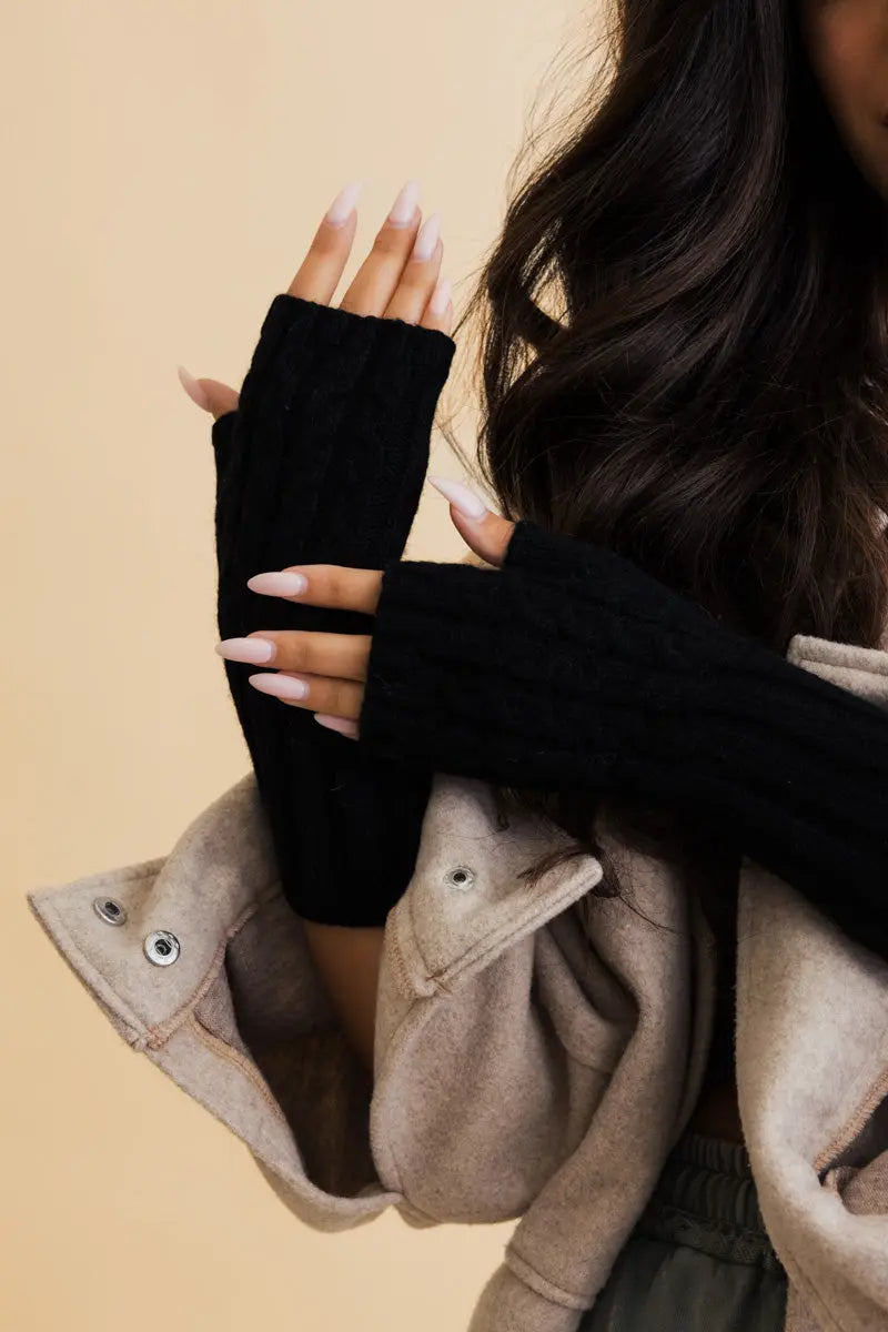 Black cable-knit fingerless gloves with ribbed cuffs and open finger design