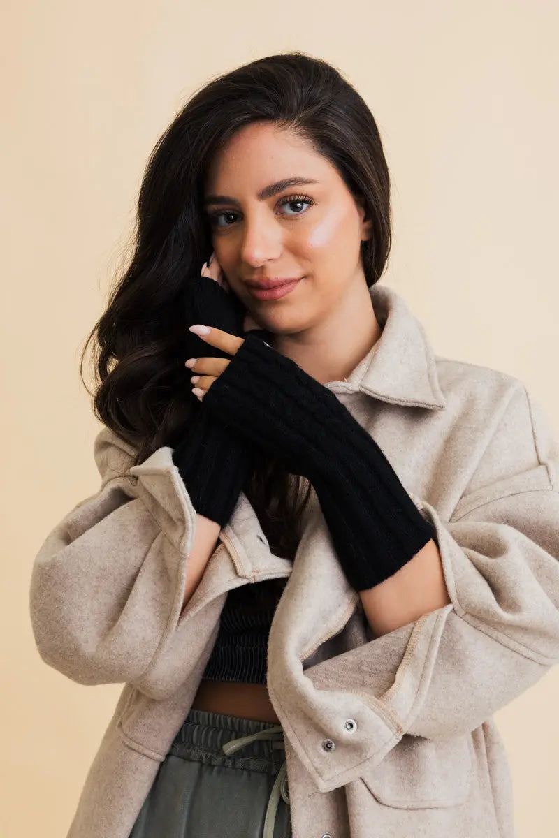 Black cable-knit fingerless gloves covering the back of the hand with open fingers
