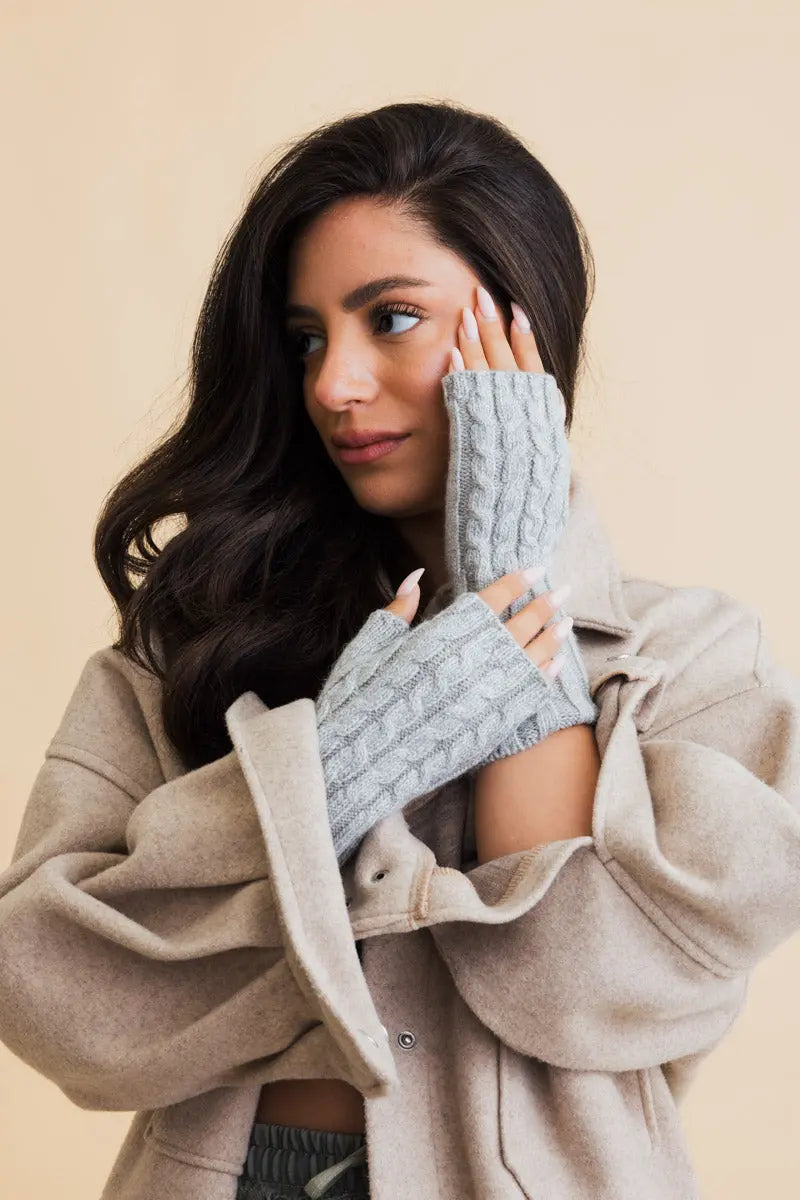 Ivory cable-knit fingerless gloves with textured cable rows and wide cuffs