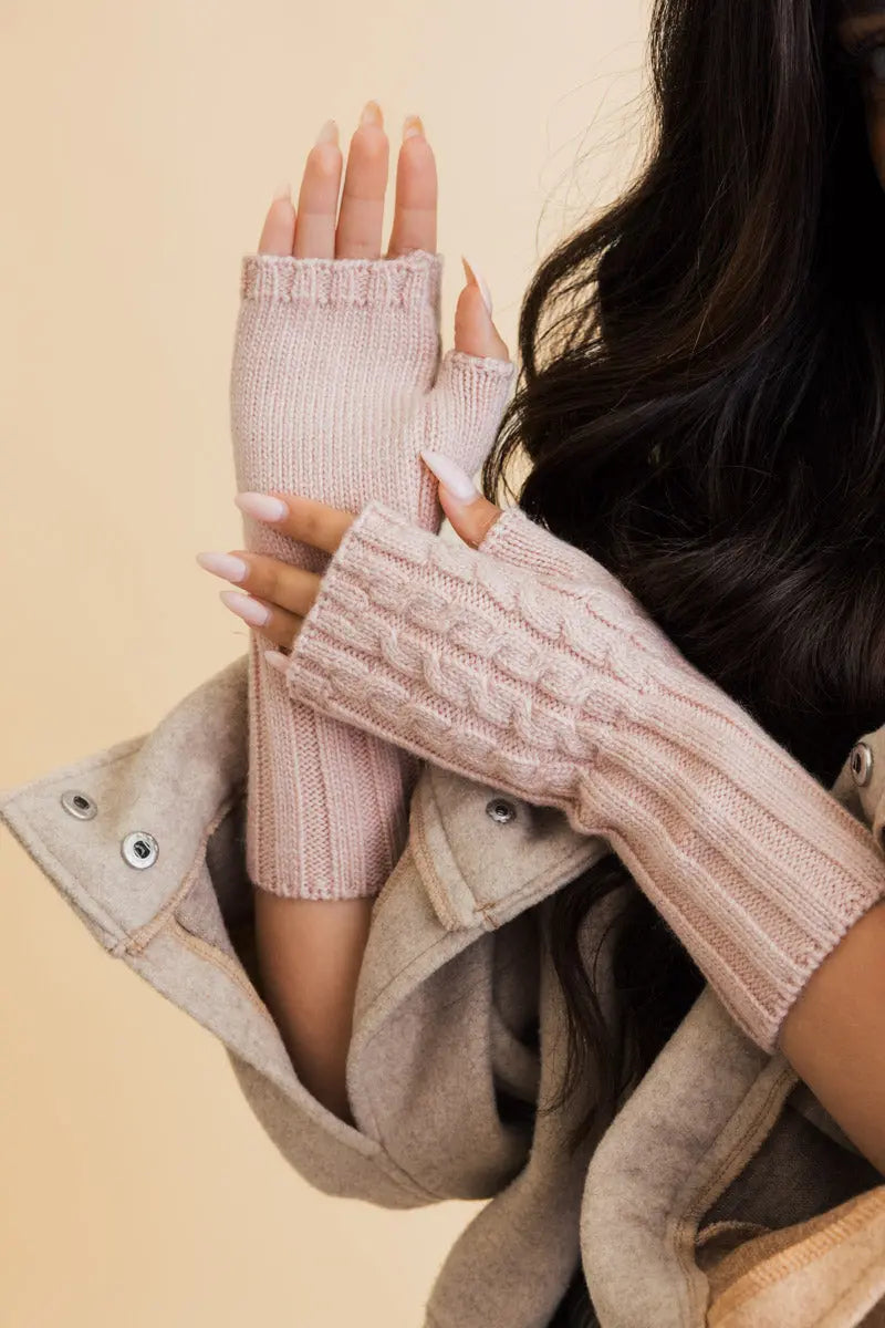 Pink cable-knit fingerless gloves with open fingers and close-up cable stitching
