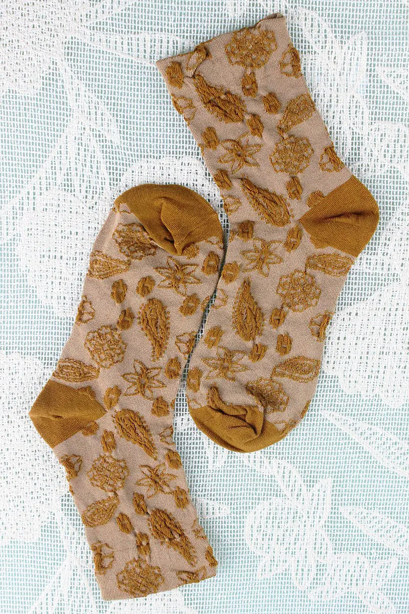 Mustard cashew-print crew socks with repeating nut and leaf motifs