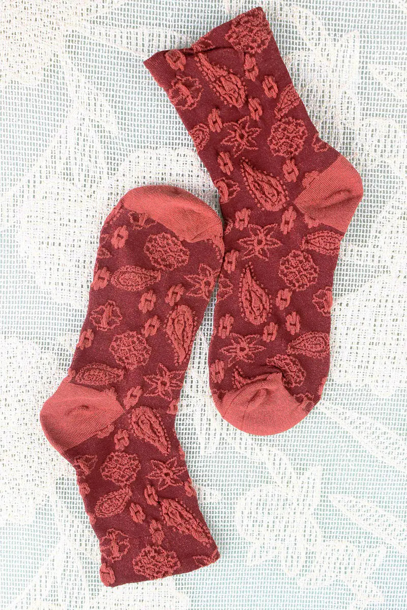 Red cashew-print crew socks with repeating nut and leaf-like motifs