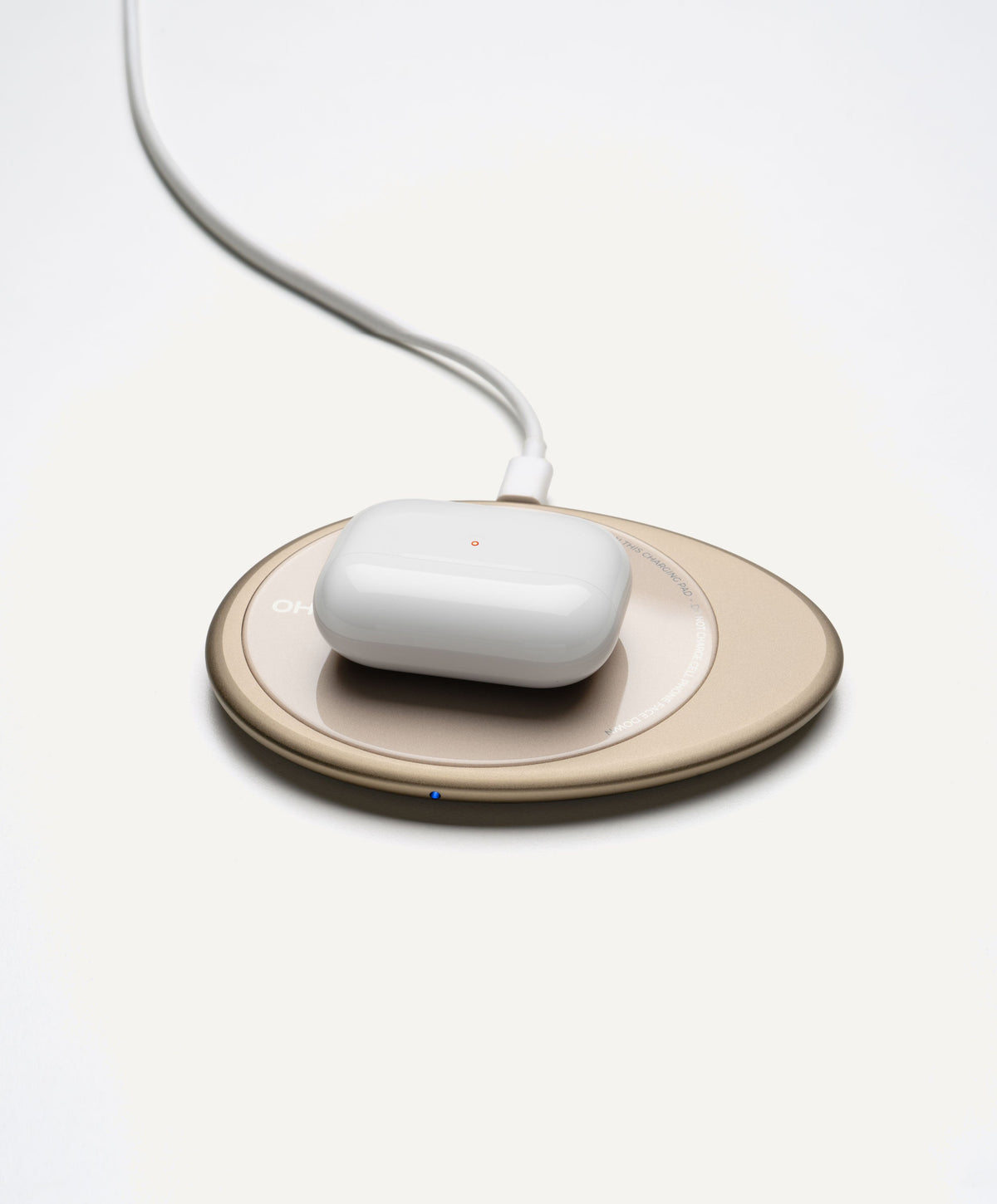 Wireless charging base: white charging puck on round coaster with cord