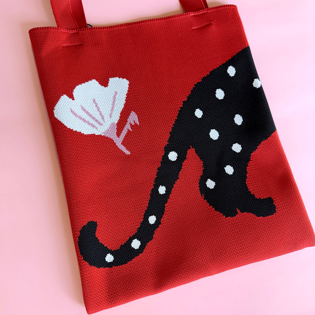 Red knit tote bag with large black cat graphic and white dot spots.