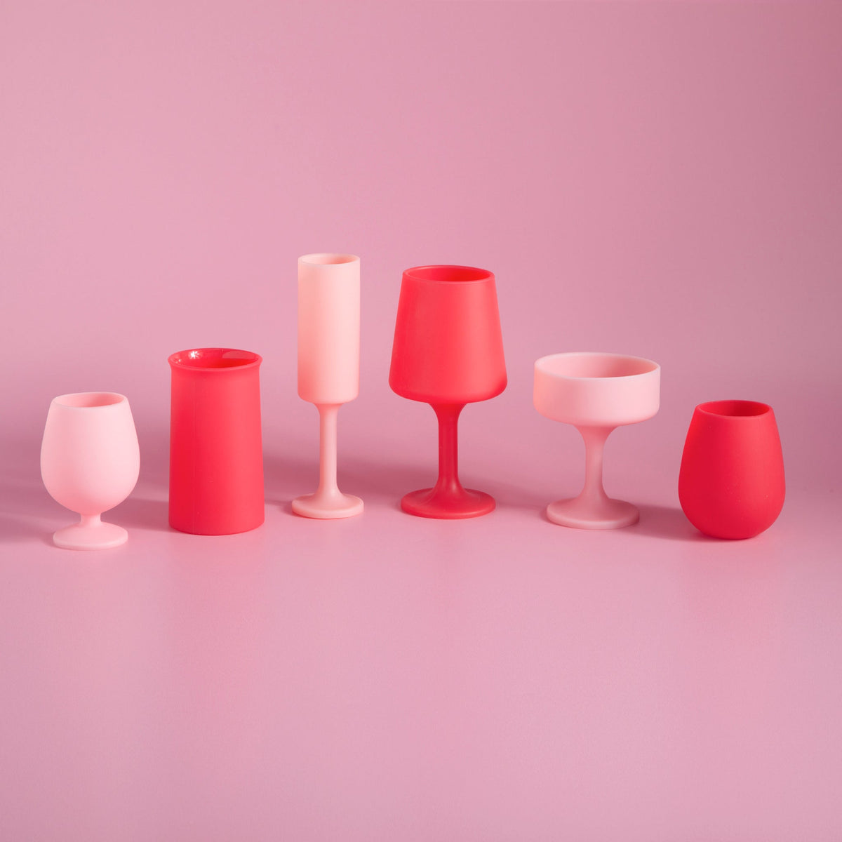 Collection of silicone tulip glasses in blush pink and cherry red, assorted cups