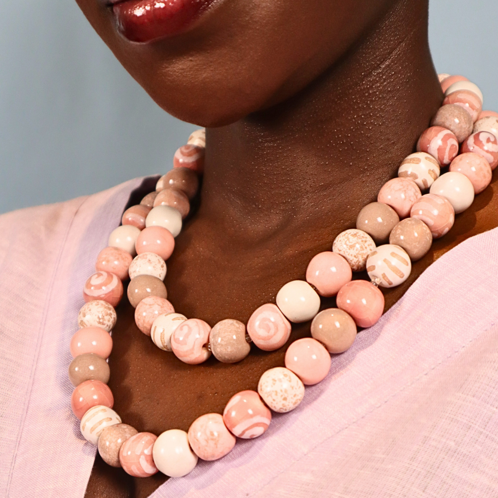 Layered pink round beaded necklaces with speckled and striped beads