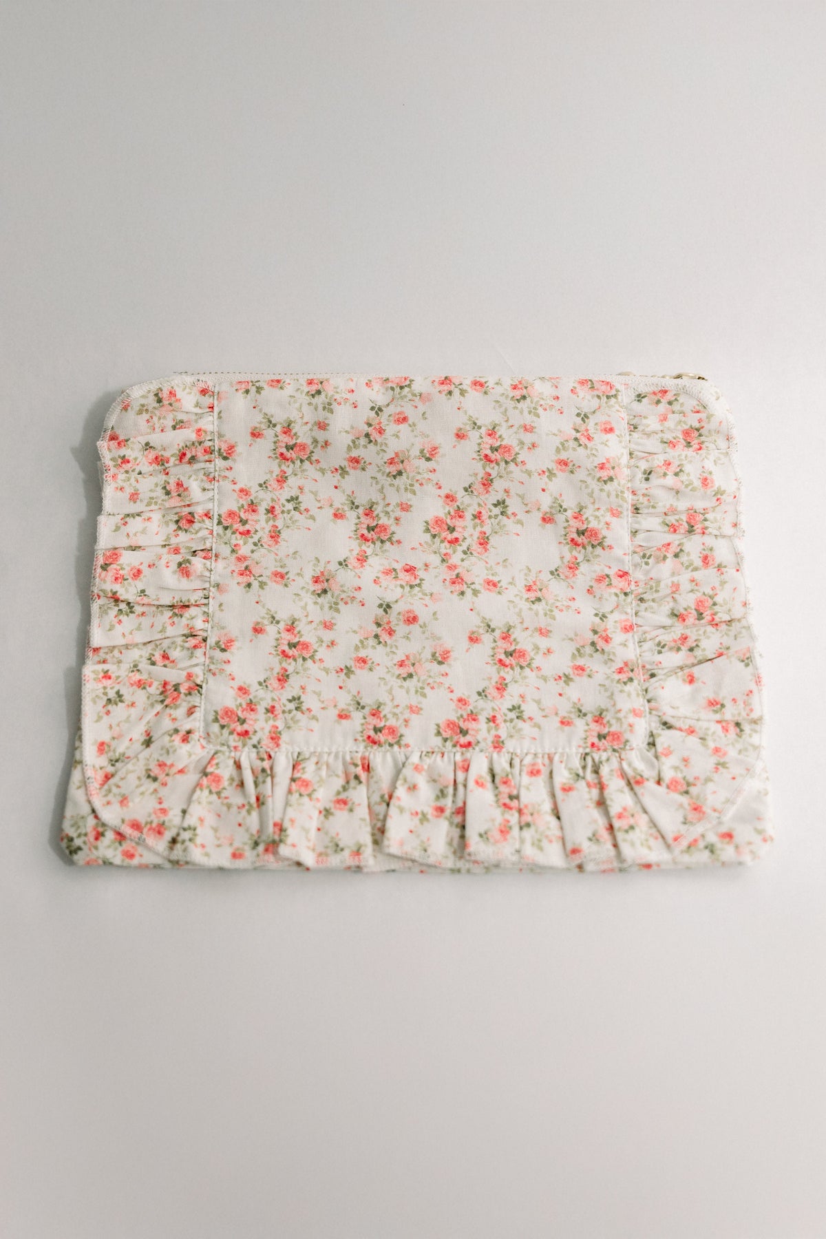 White floral ruffle zipper pouch with gathered hem and pleated panels