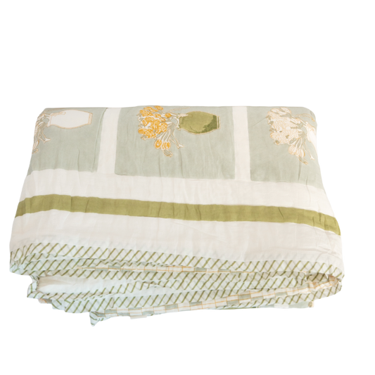 Quilt with sage green and cream patchwork floral print, folded