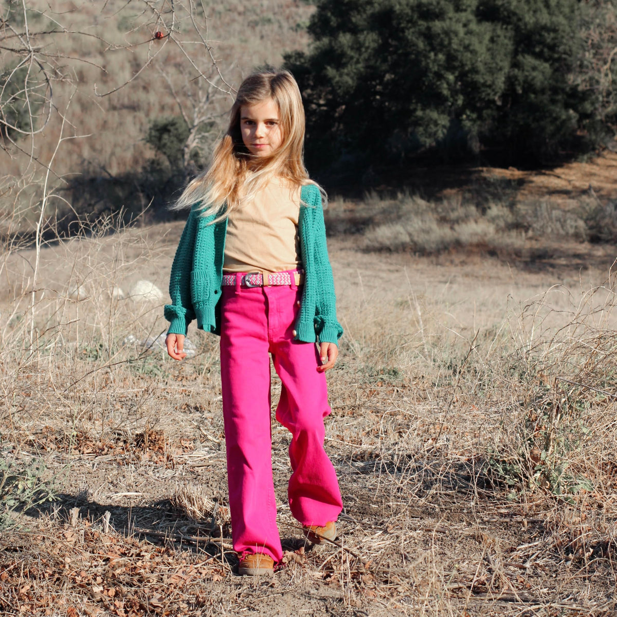Pink, gray, and white braided belt worn with pink pants on a child