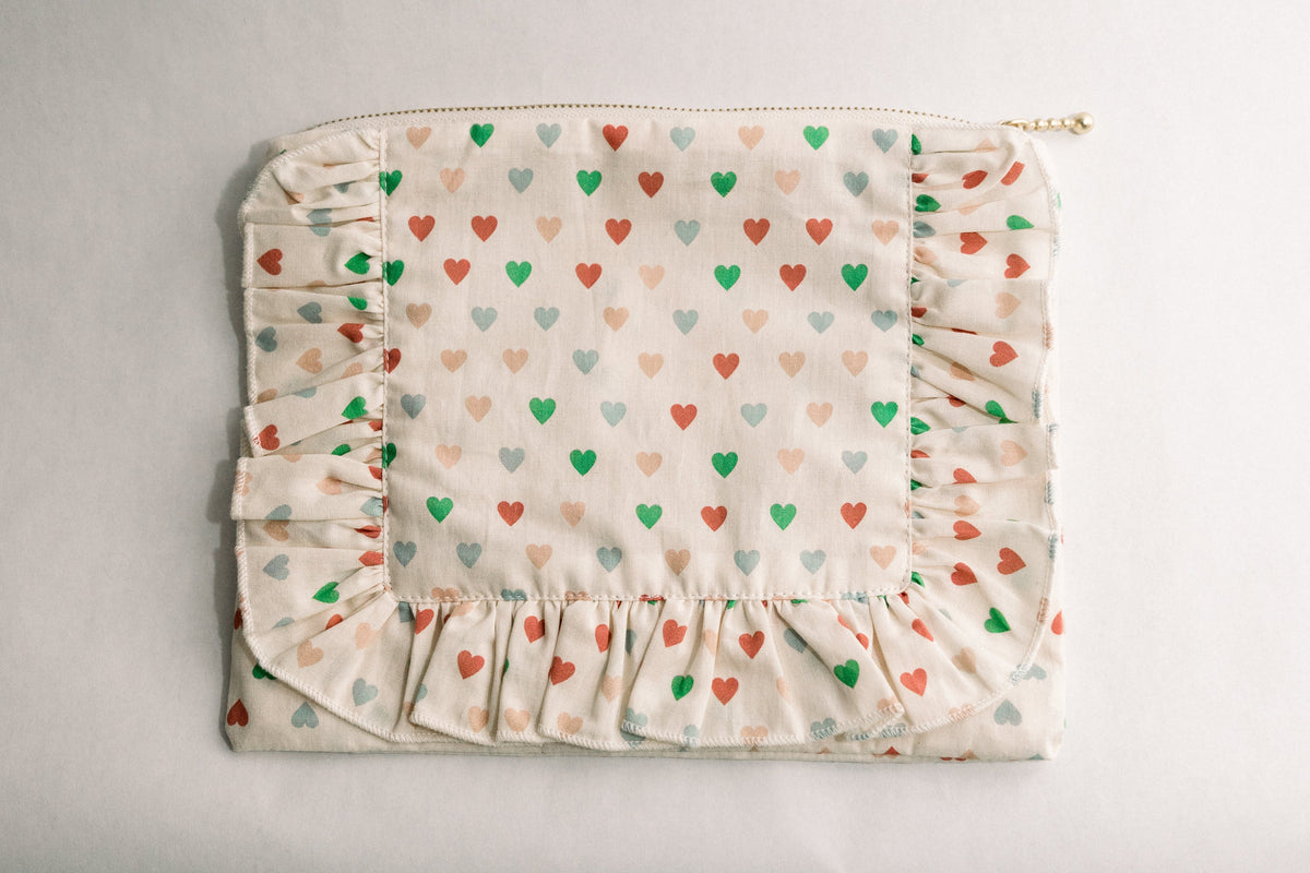 Heart-print ruffle zipper pouch with multicolor hearts and gathered bottom ruffle