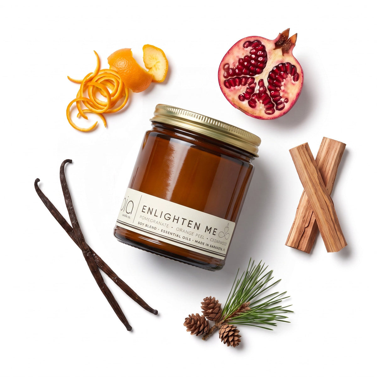 Soy blend candle amber jar with lid, shown with orange, pomegranate, and vanilla accents