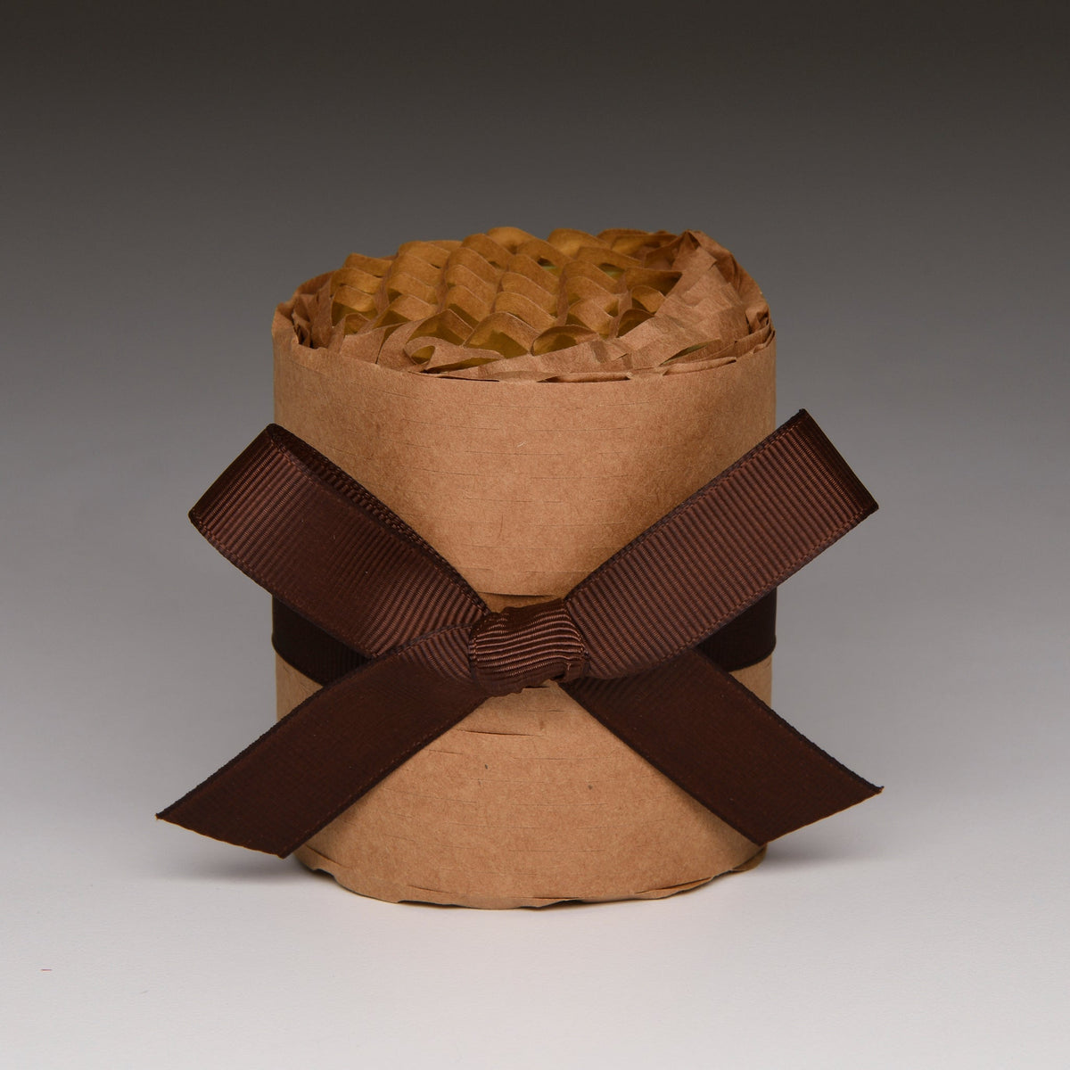 Kraft paper wrapped candle with crisscross ribbon bow