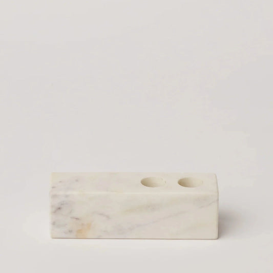 Marble candle holder block with two round openings, white veined stone