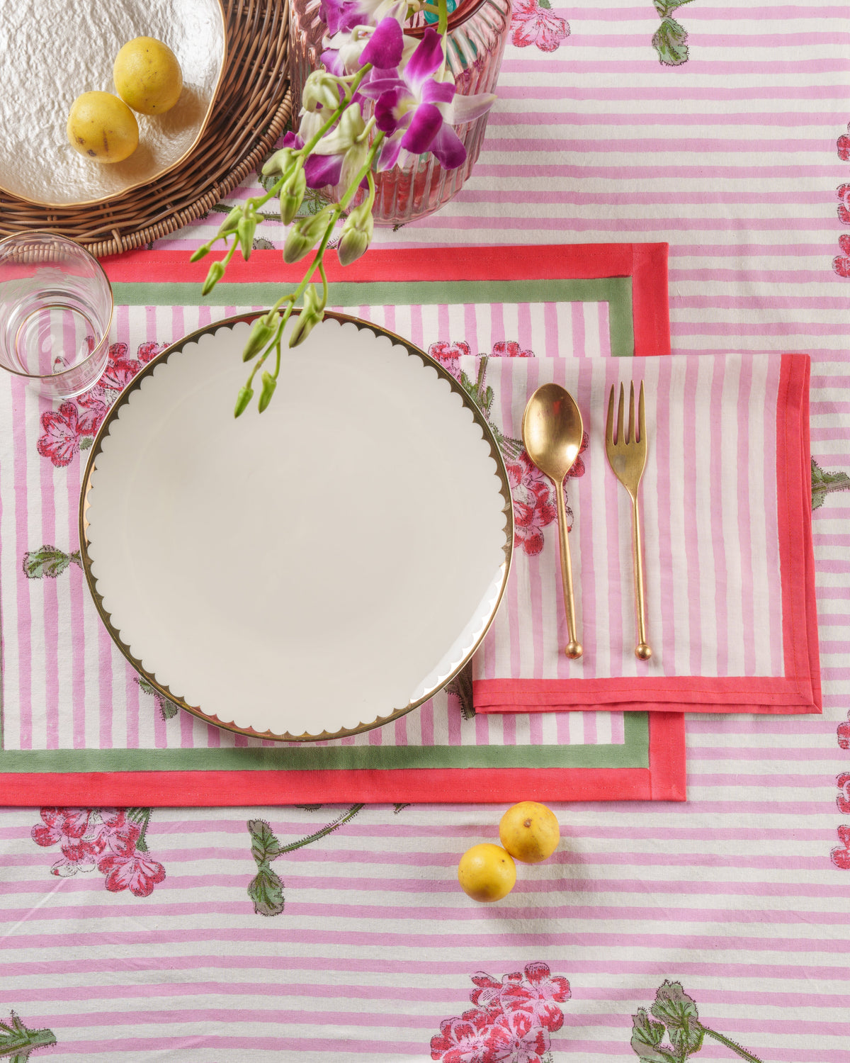 Pink hydrangea blockprint placemat set with red border, striped fabric, scalloped plate