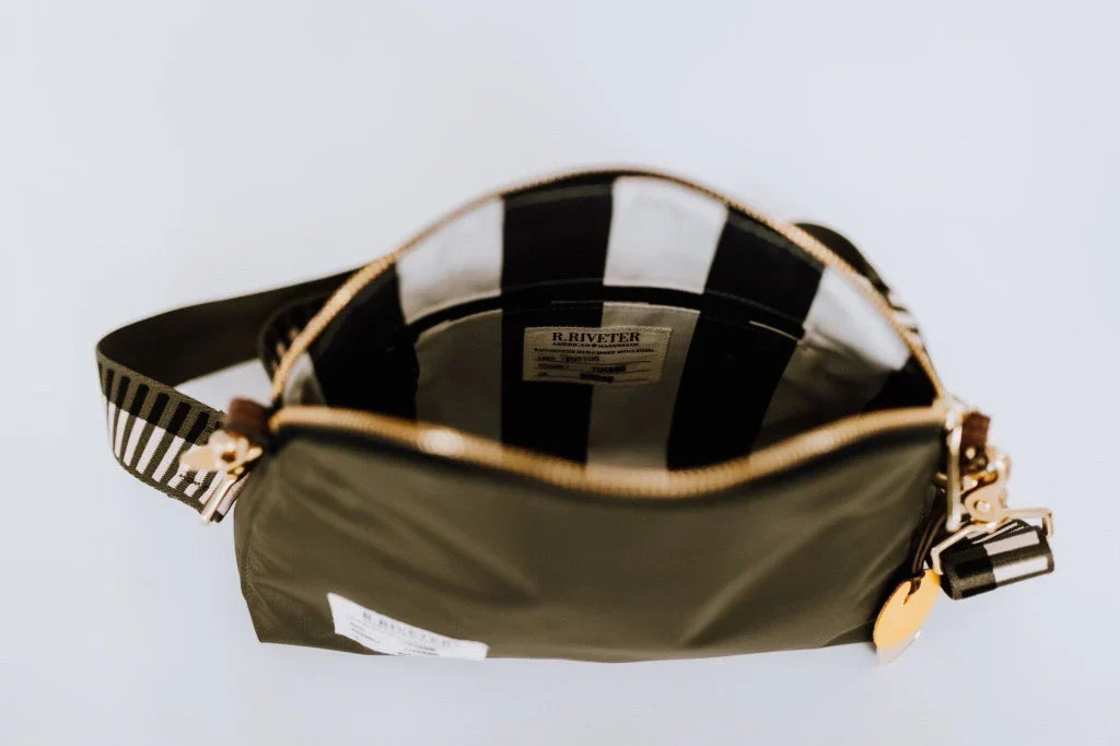 Open olive nylon pouch with black-and-white striped lining and gold zipper hardware