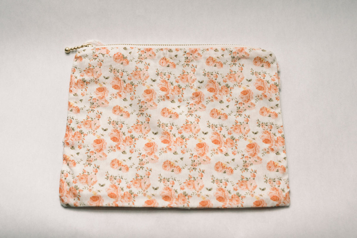 Floral zipper pouch with coral flower print and frilled edges; zipper closure at top