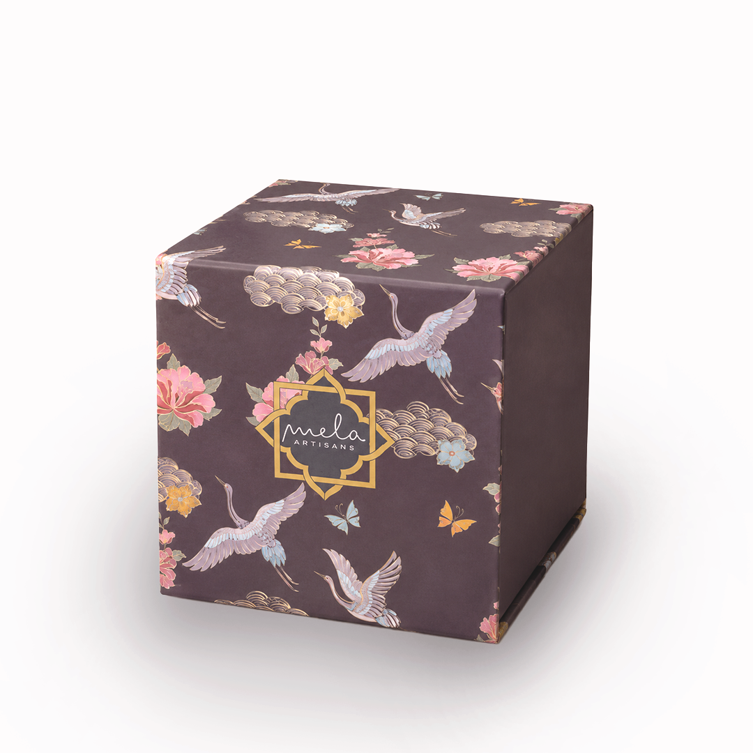 Small cube decorative gift box in dark brown with floral-crane print and “mela” logo