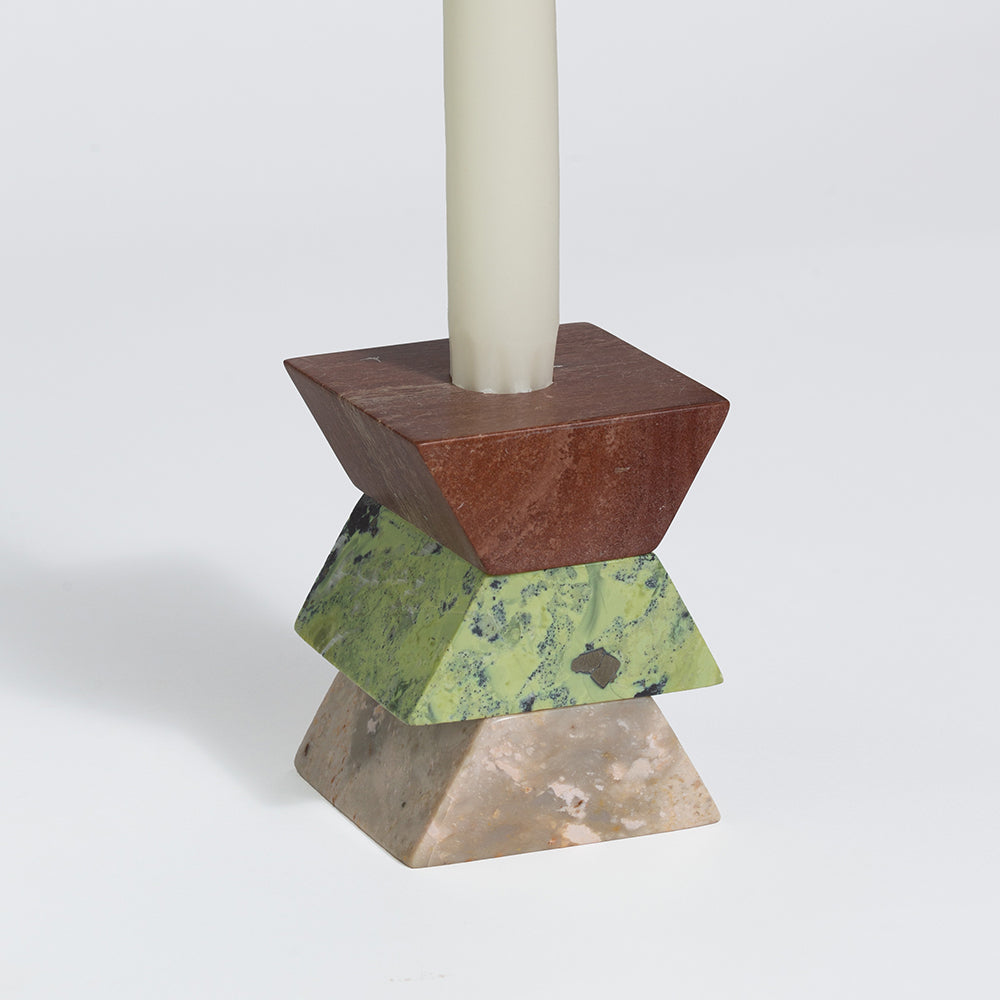Stackable triangular candelabra with tall candle on three stacked metal pieces