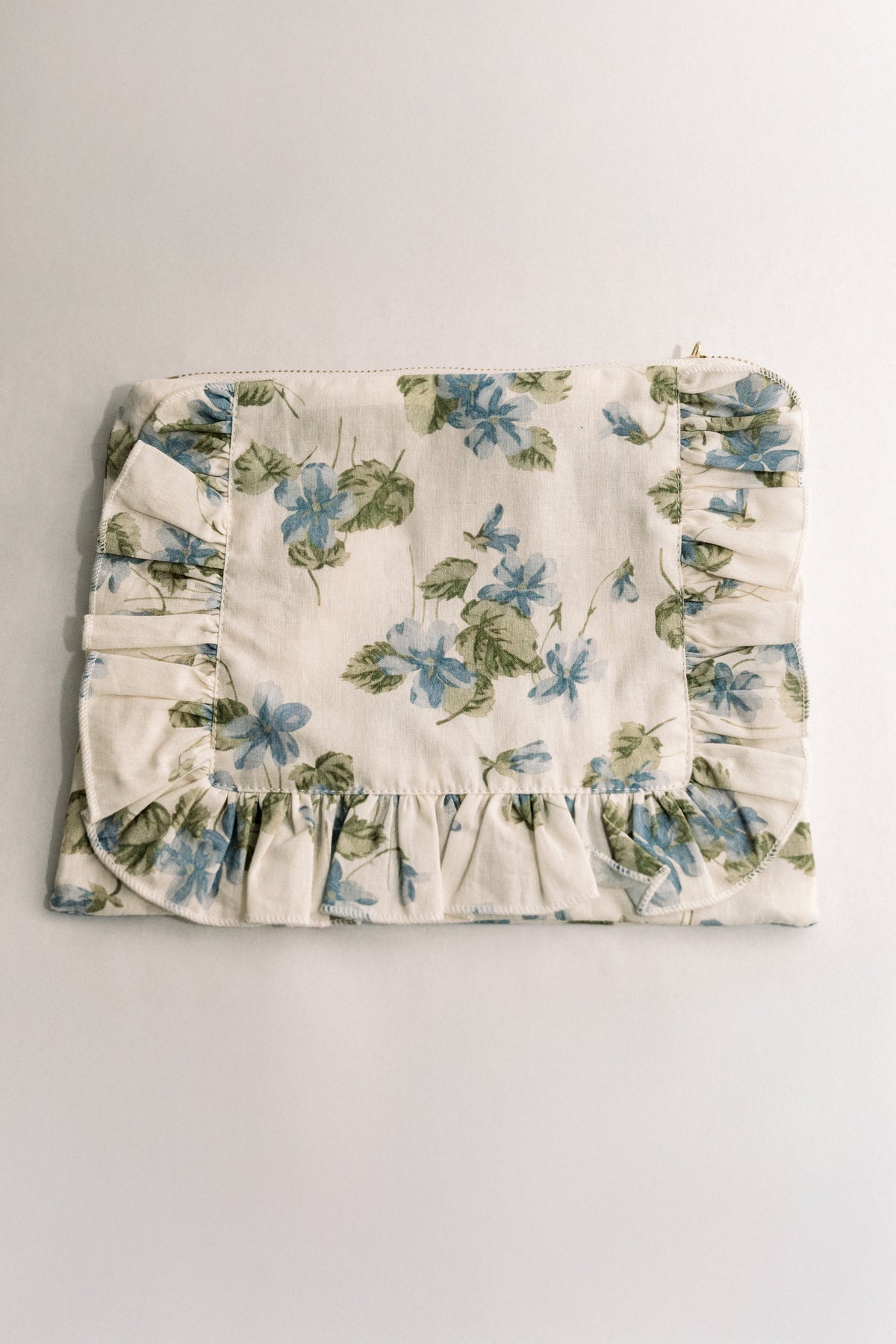 Cream floral ruffle zipper pouch with blue and green botanical print and ruched bottom