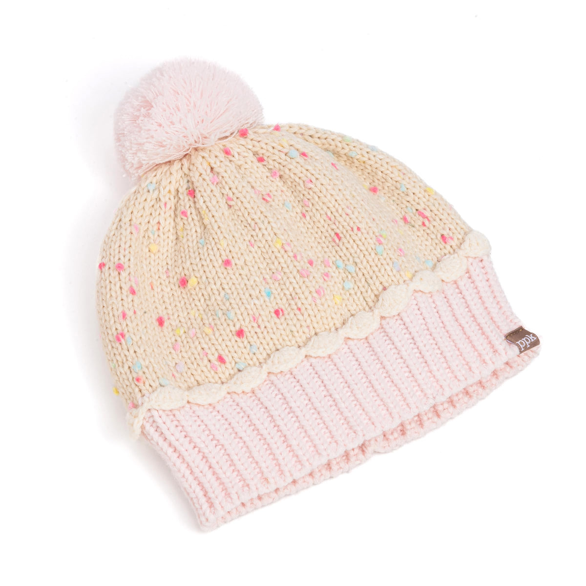 Angled view of cream sprinkle-knit beanie with pink pom-pom and pale pink ribbed cuff