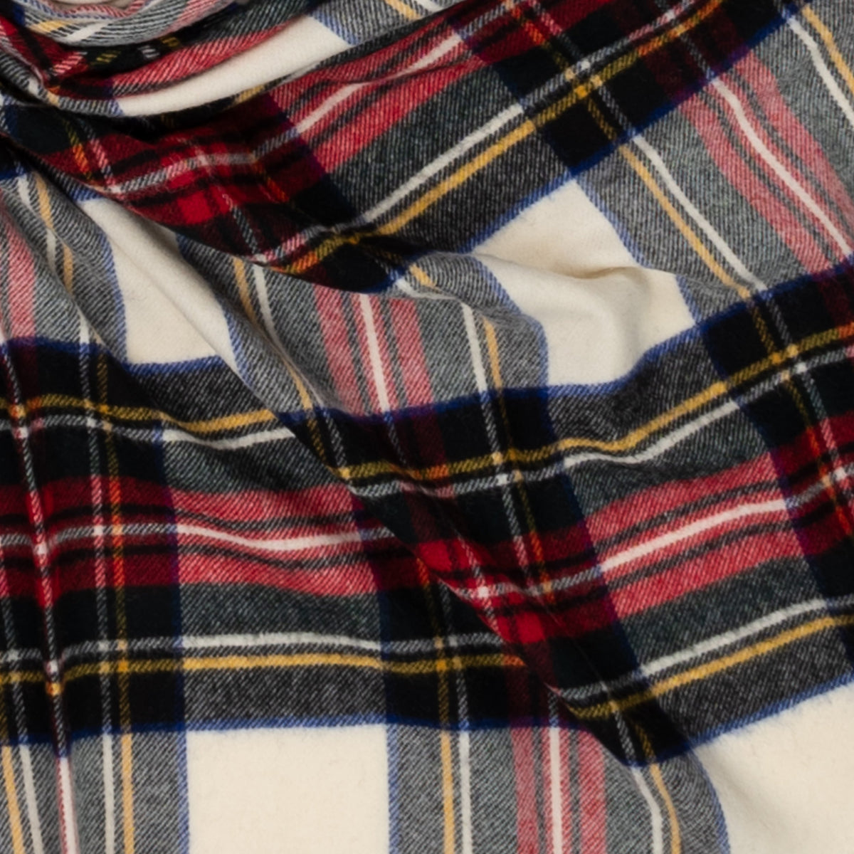 Close-up of woven tartan pattern with red, navy, gray, and cream plaid stripes
