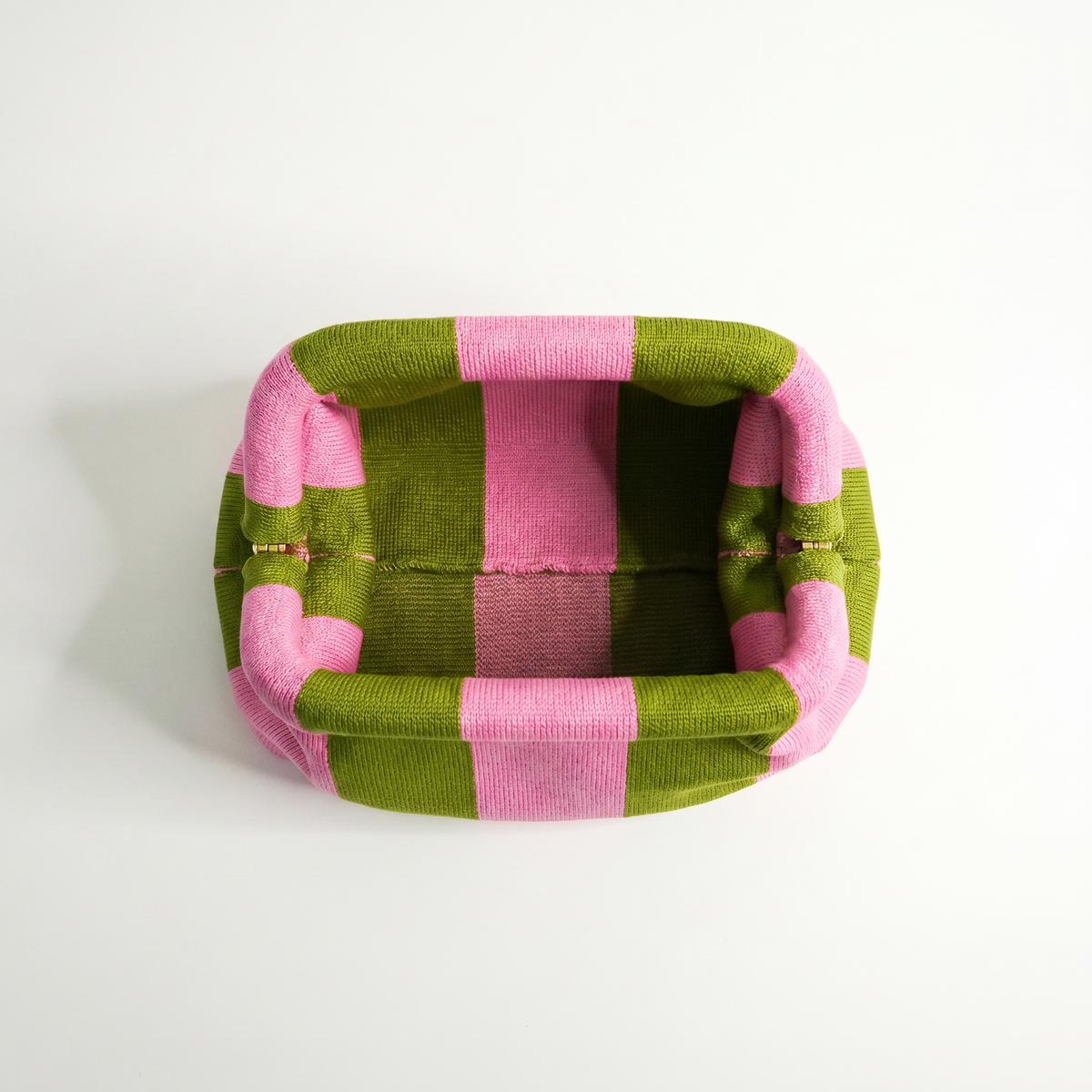 Green and pink striped clutch bag interior view with open top and fabric lining