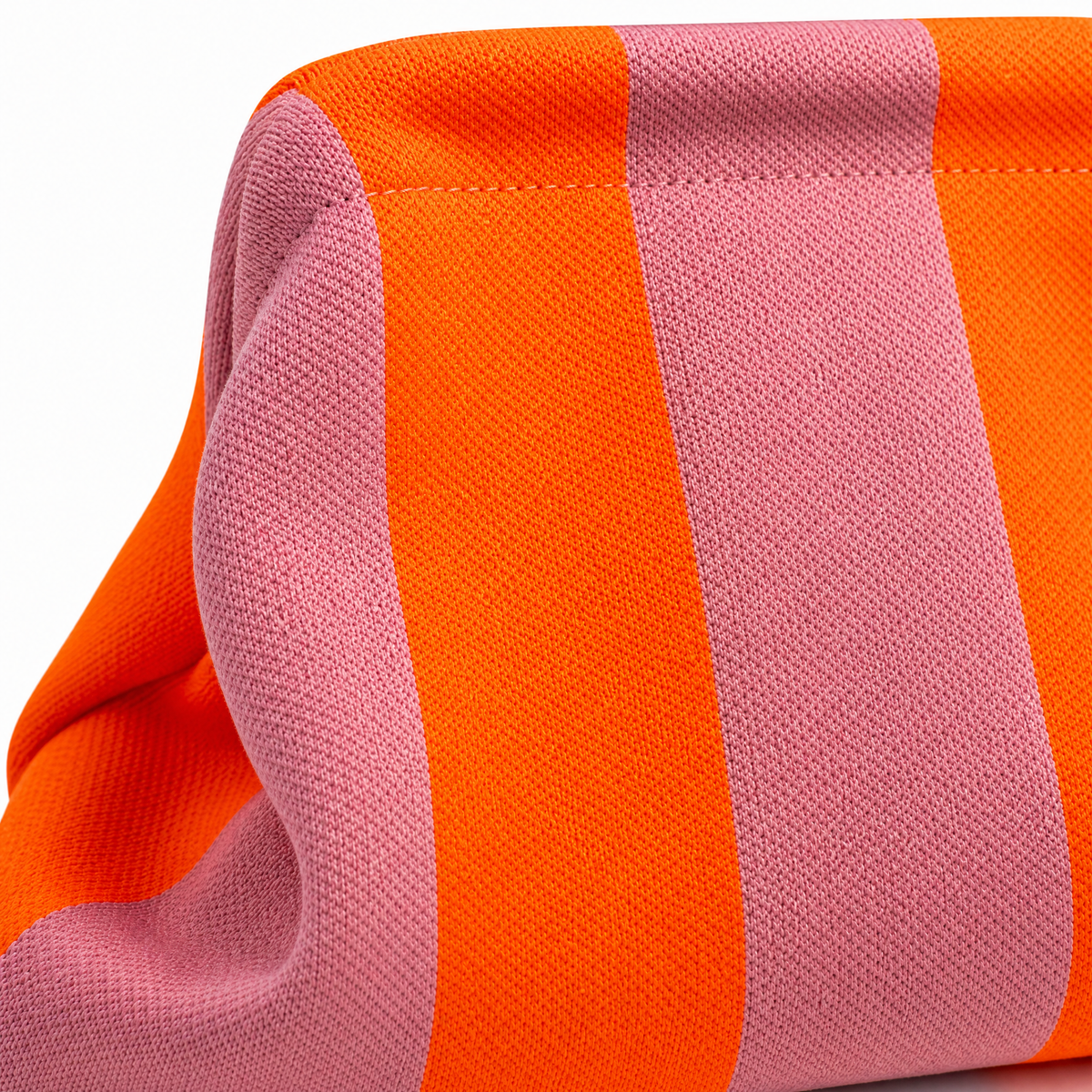 Orange and pink striped fabric clutch close-up with textured weave and stitching