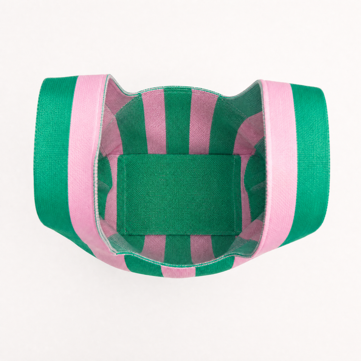 Handbag opening view with green interior panel and green-pink striped fabric handles