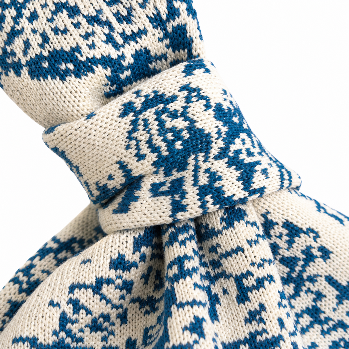 Close-up of blue-and-white woven fabric with patterned knot and tied drawstring