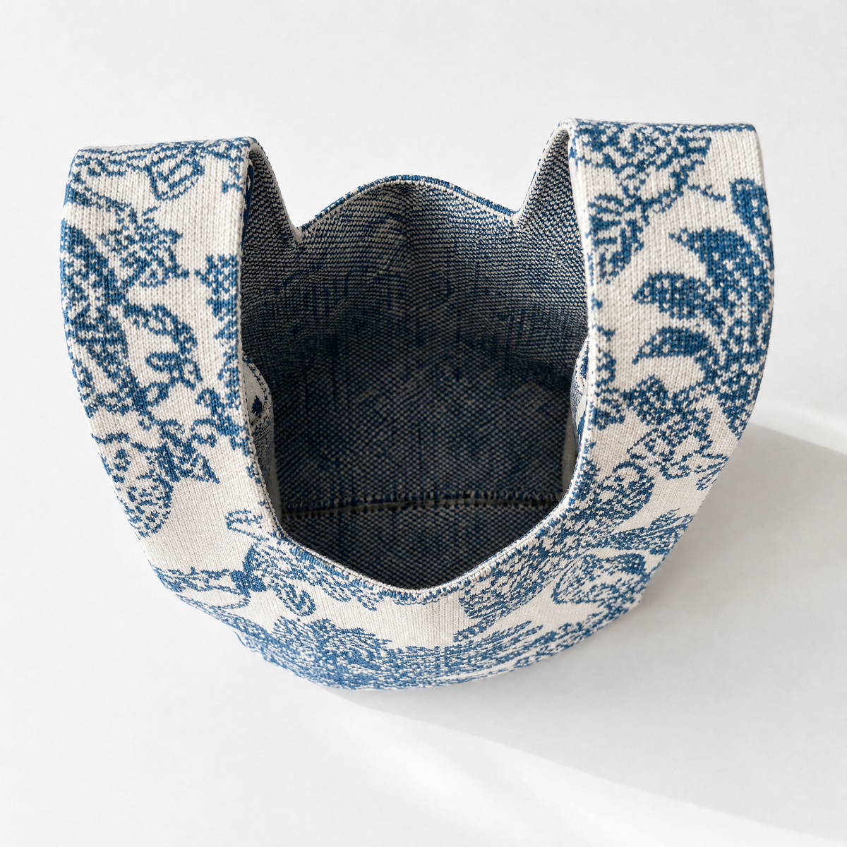 Blue and white woven handbag pouch with open top and dark interior lining