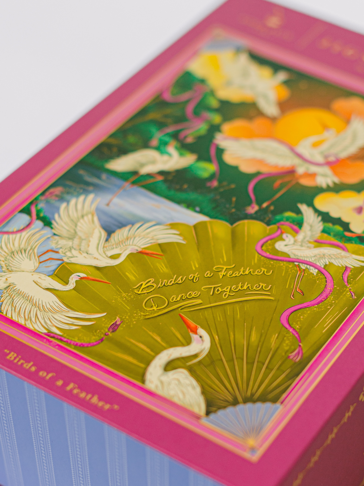 Close-up of puzzle artwork with white birds, orange accents, and gold center text