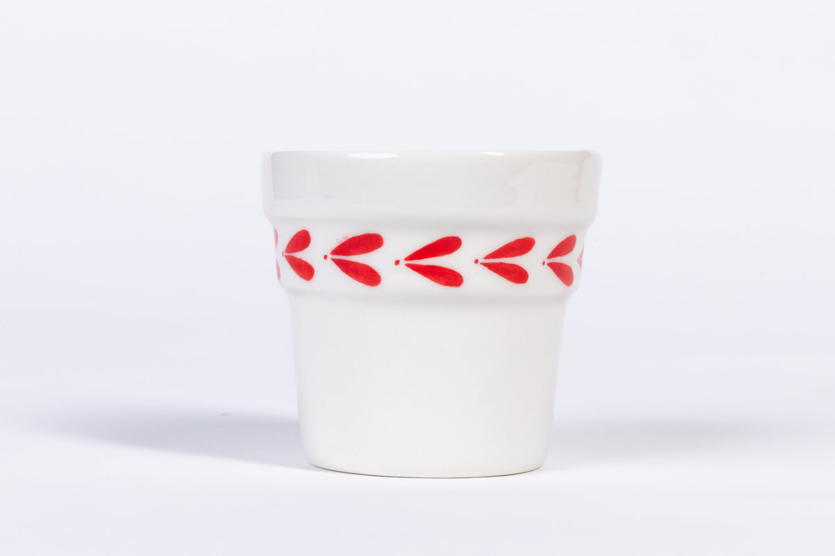 White ceramic espresso cup with red leaf band around the middle