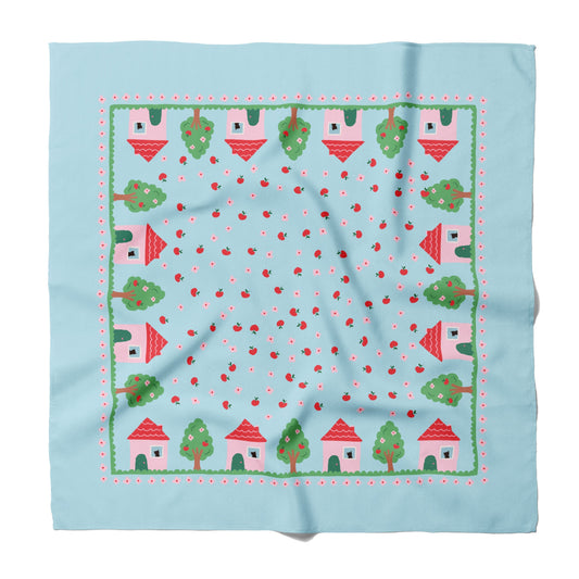 Light blue silk square scarf with village, trees, and red trim pattern border.