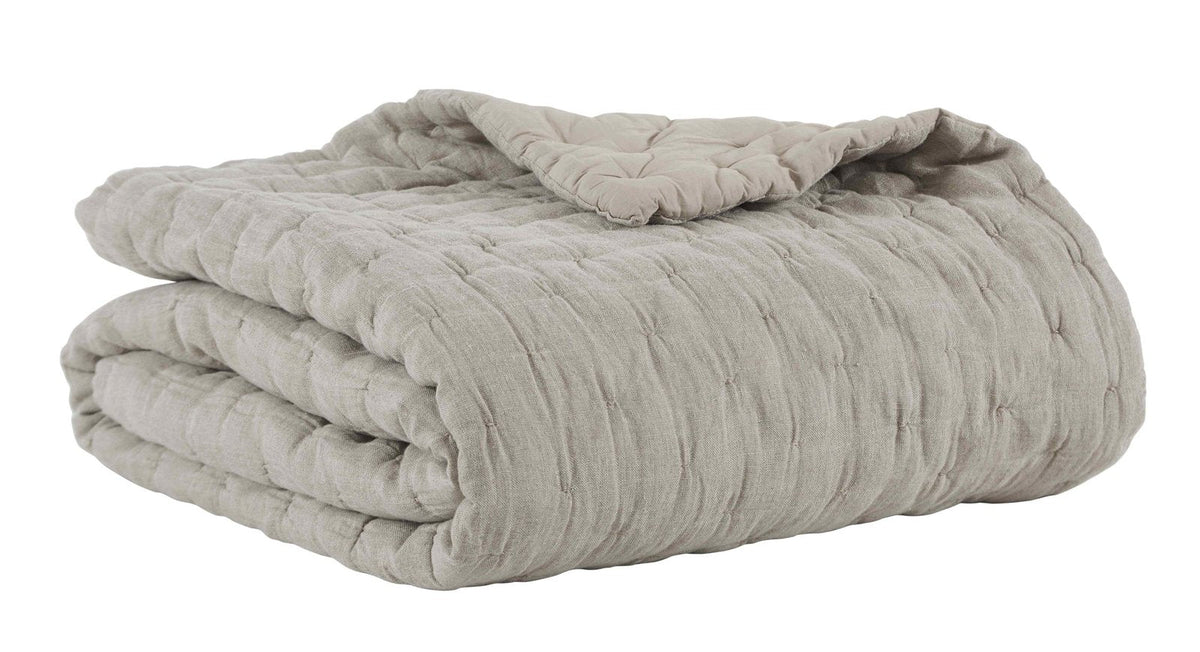 Natural linen quilt folded stack with pinched quilting ridges and thickness.