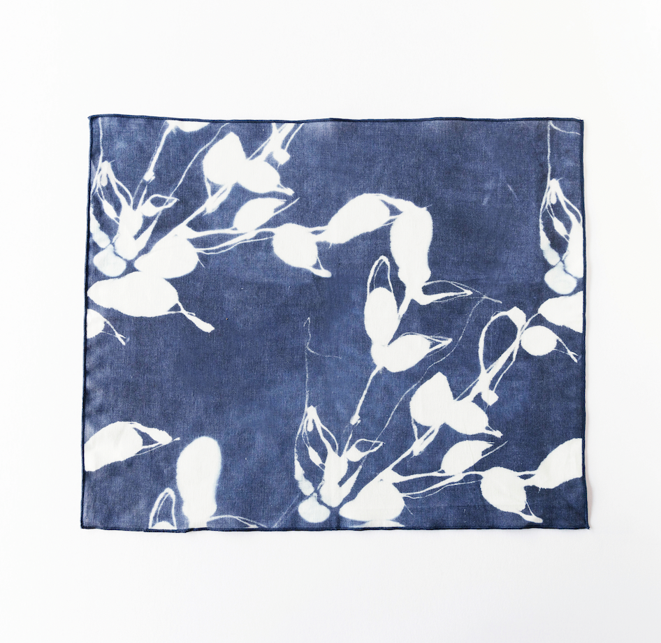 Indigo placemat with white bird-and-flower print, rectangular with stitched border