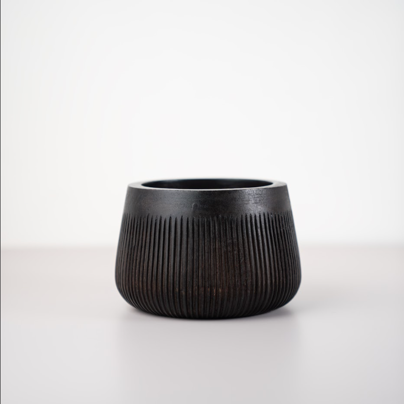Small black ceramic bowl with vertical ribbing and rounded flared rim