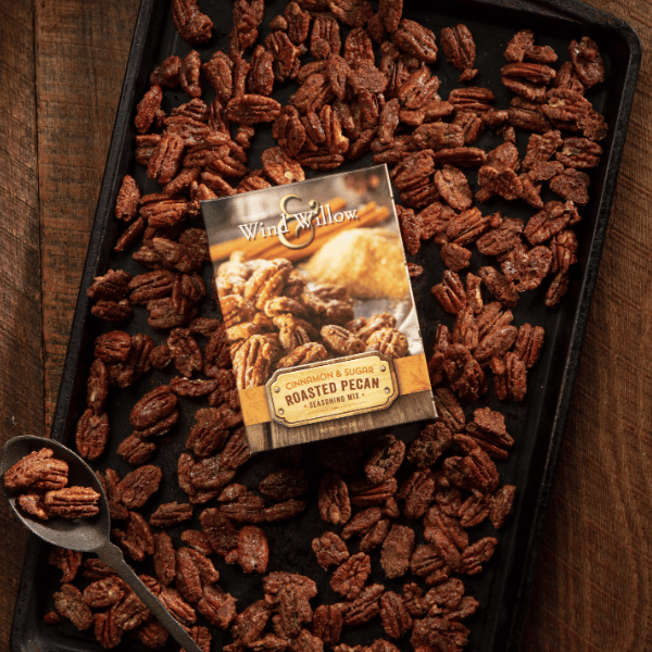 Cinnamon & sugar roasted pecan seasoning mix packet on tray of roasted pecans