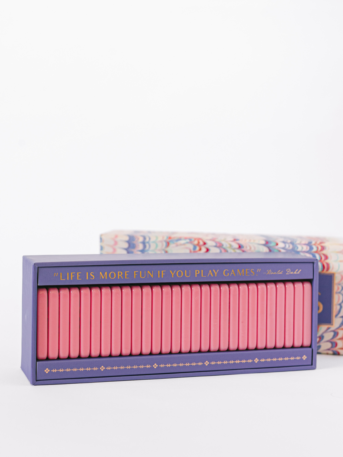 Open domino box showing rows of pink tiles with yellow dot pips