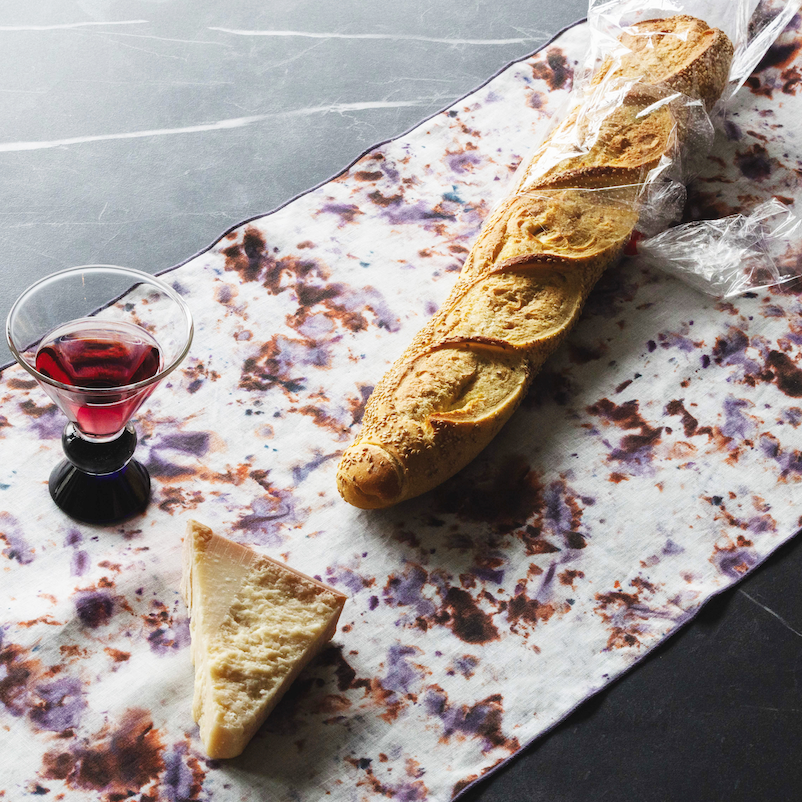 Marble-pattern table runner with white base and brown rose speckles, dark edge trim