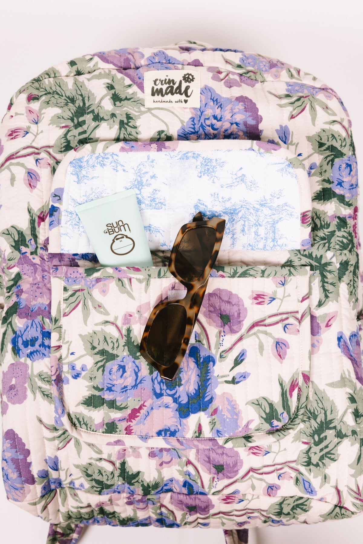 Quilted floral backpack back view with interior label and open pocket
