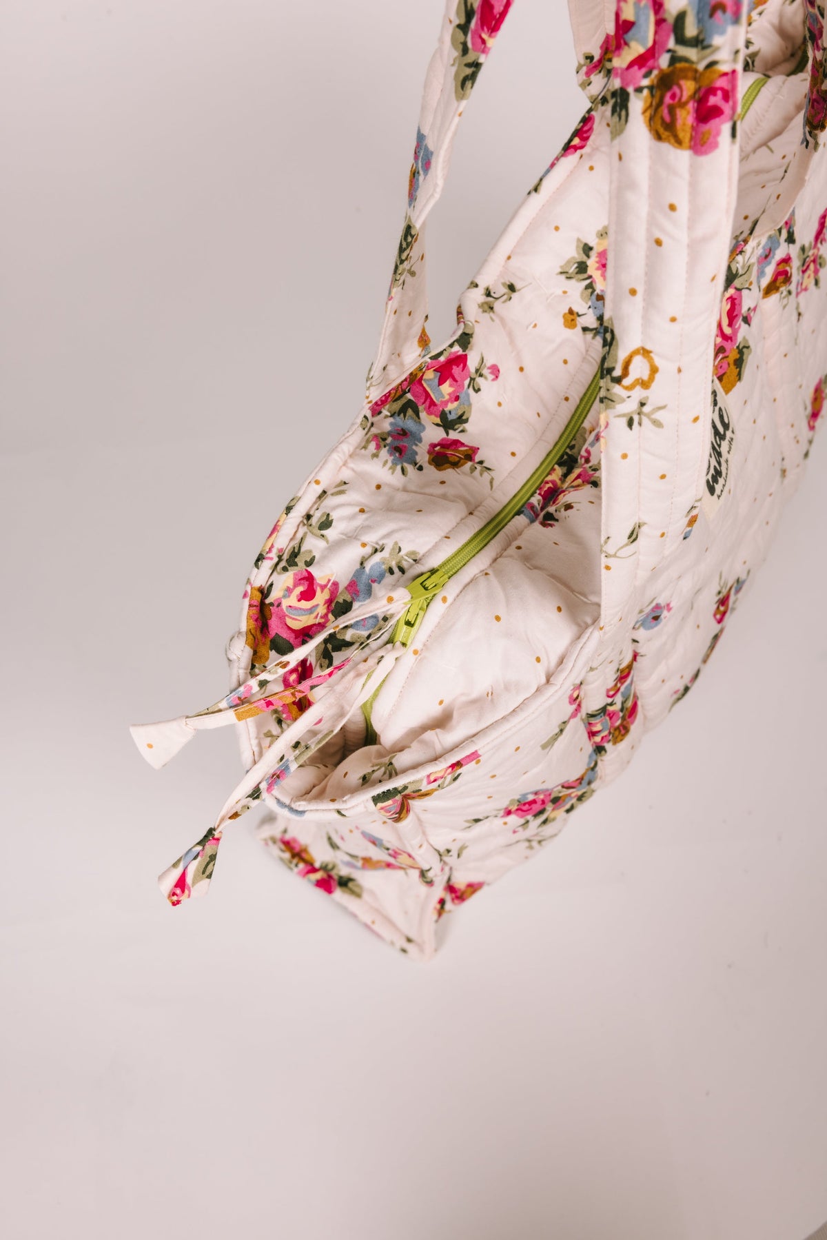 Floral zip tote bag angled view, open zip and roomy interior visible