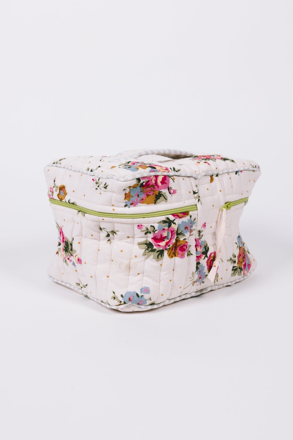Floral quilted travel case in white with lime zipper and carrying handle, front view
