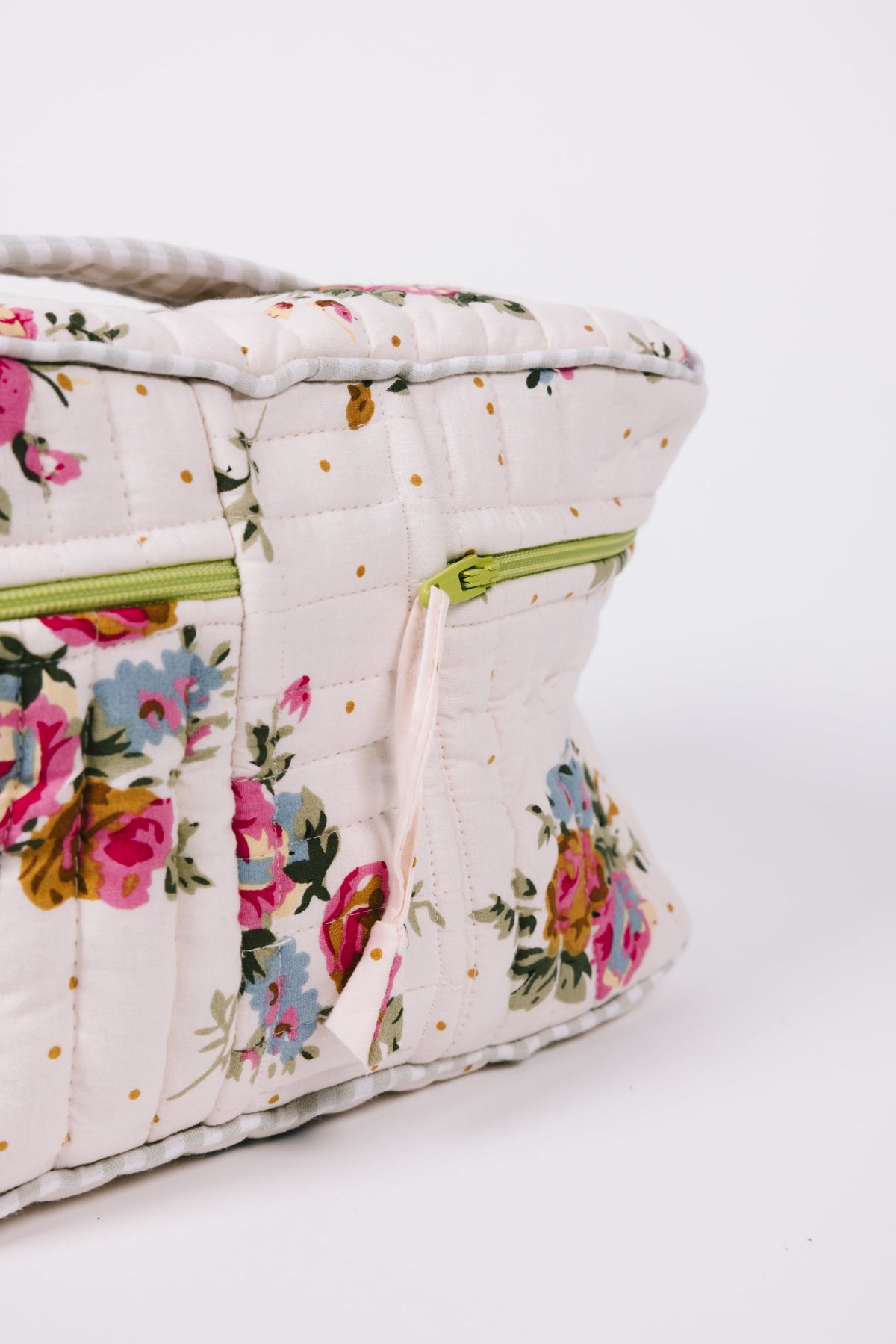 Floral quilted travel case with lime zipper and handle, side view