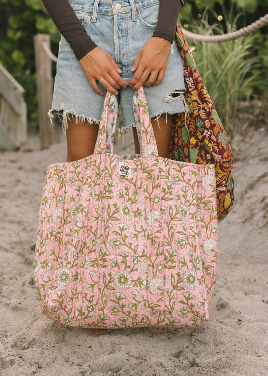 Pink floral tote bag with short handles, held open at the top