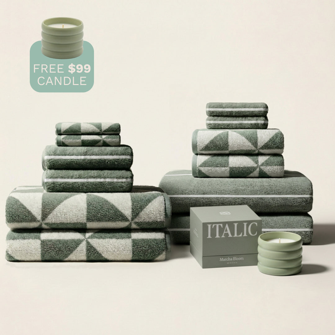 Green and ecru patterned cotton towels in multiple folded stacks