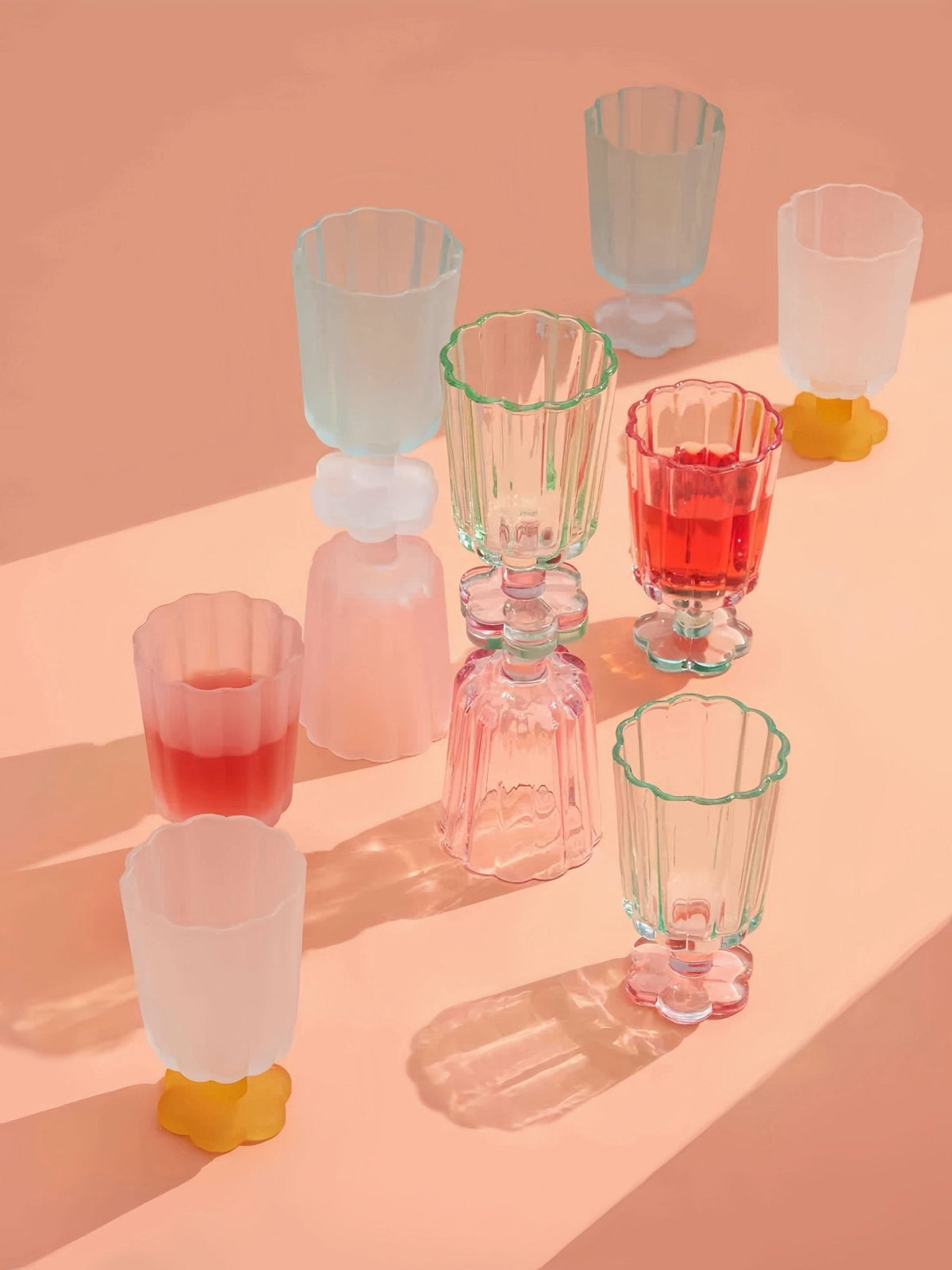 Mixed set of hand-blown petal goblets in pink, red, clear, and yellow accents.